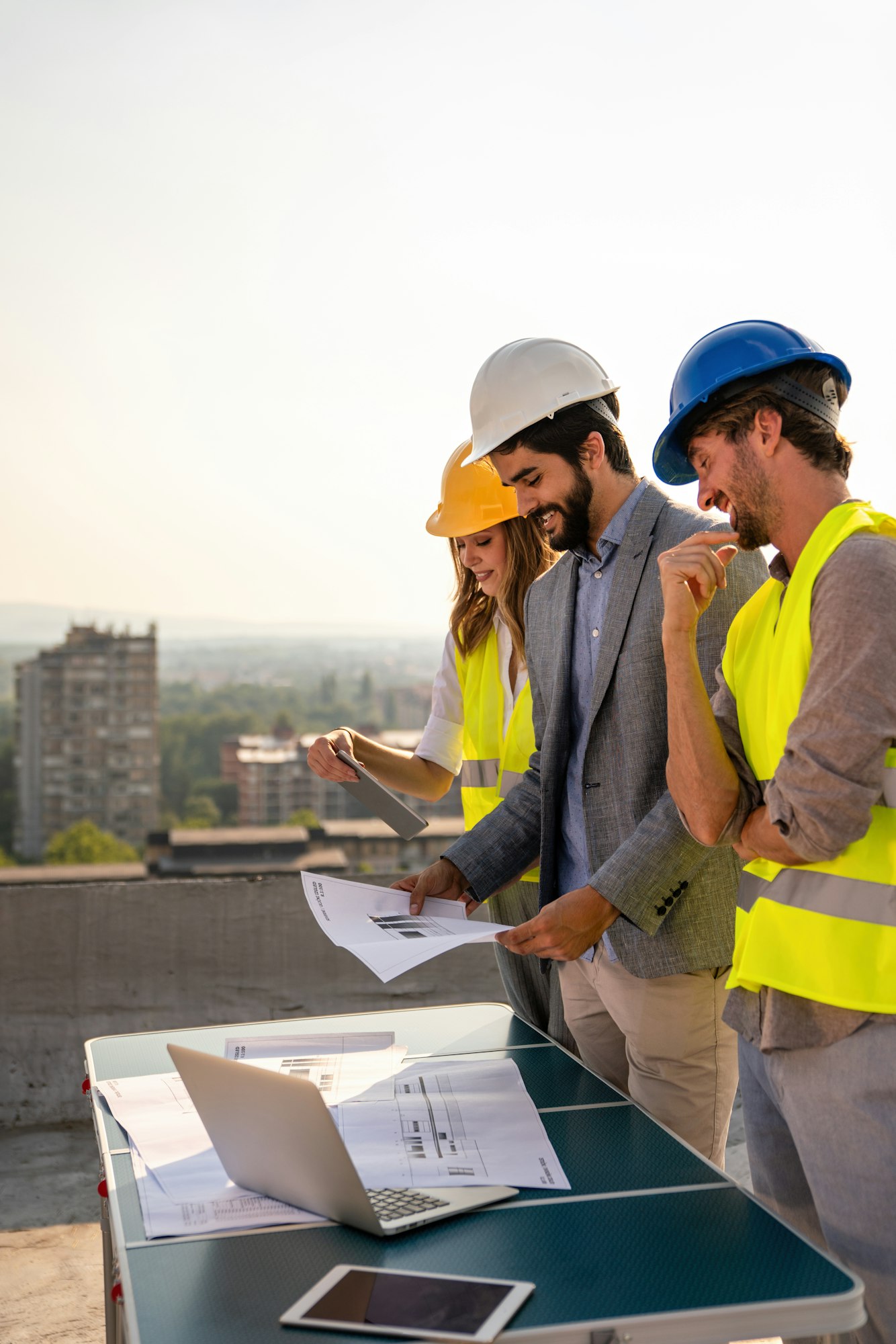 Construction concept. Engineers and architects working at construction site with blueprint